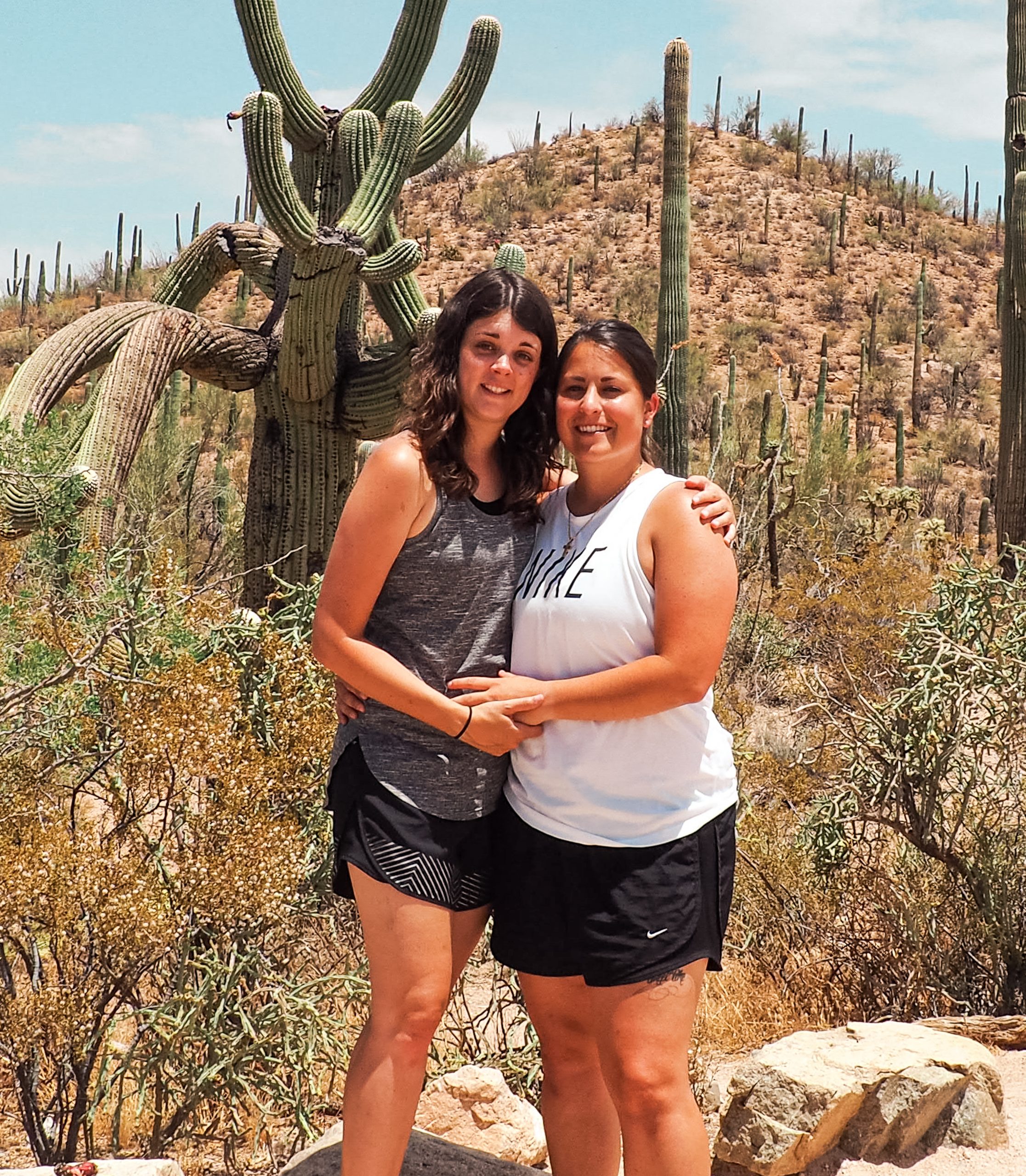 Us standing in front of a Saguaro cactus in Saguaro National Park