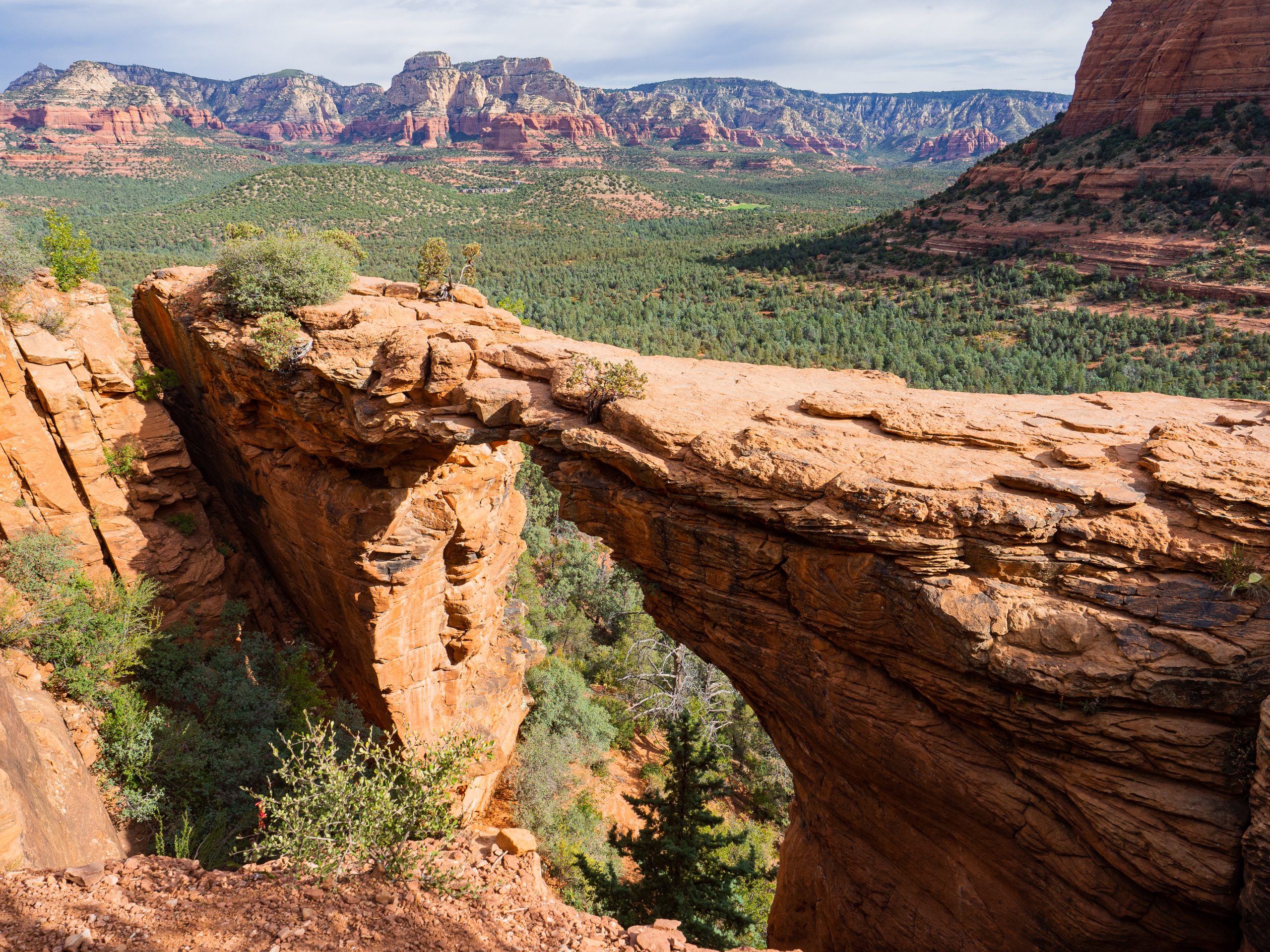 The narrow Devil's Bridge with red rocks in the background in Sedona