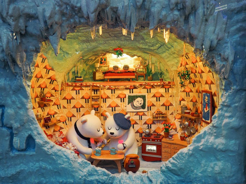 Two ice bears drinking hot chocolate in their house displayed in Macy's windows