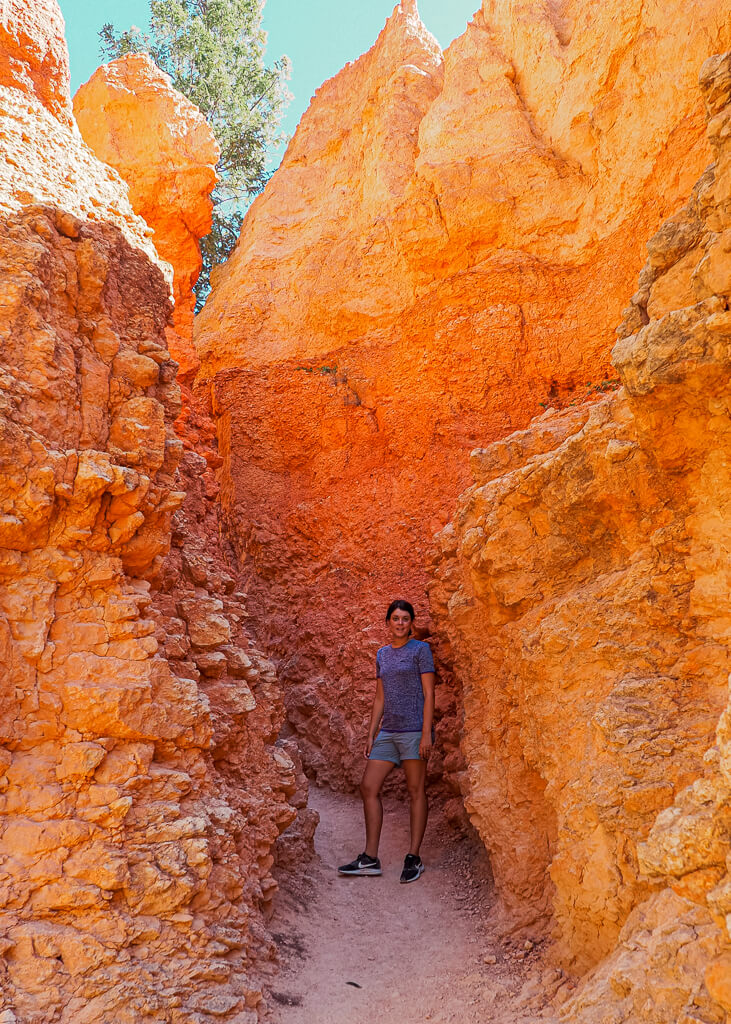Dana hiking through a narrow hoodoo formation on the Queens Garden and Navajo Loop Trail