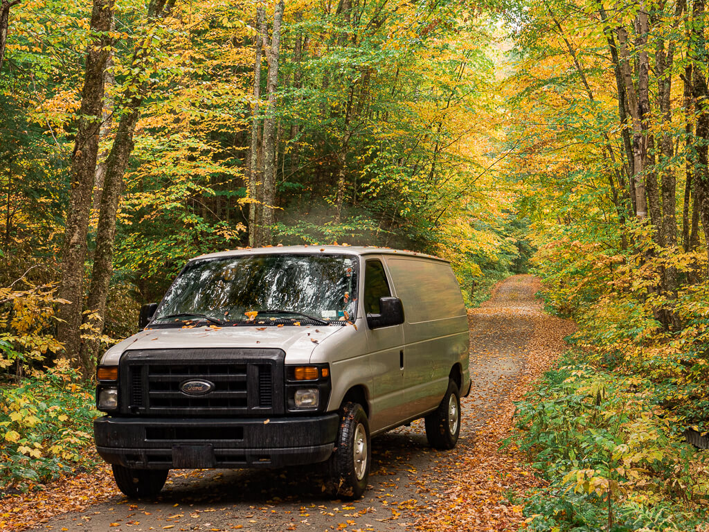 Our van driving off-road surrounded by fall coloured leaves